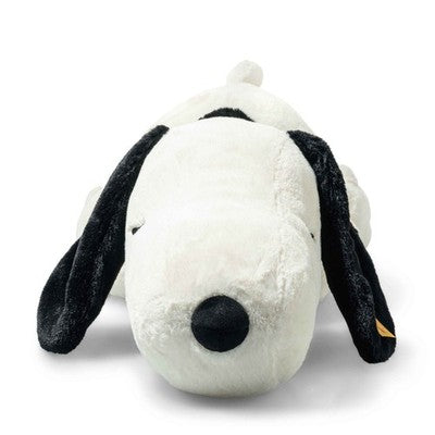 Plush toy resembling a black and white dog with a gold tag on a white background