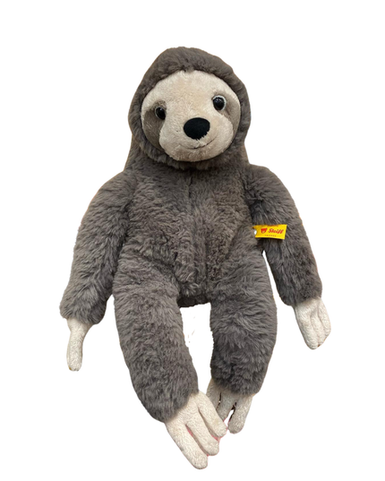 Plush toy sloth with a visible brand tag on a white background