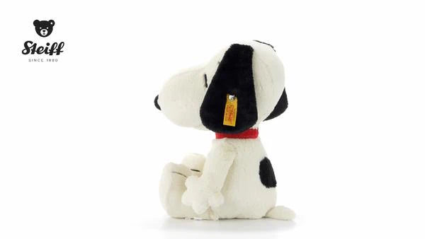 Plush dog toy with black ears and red collar on a white background, featuring the Steiff logo.