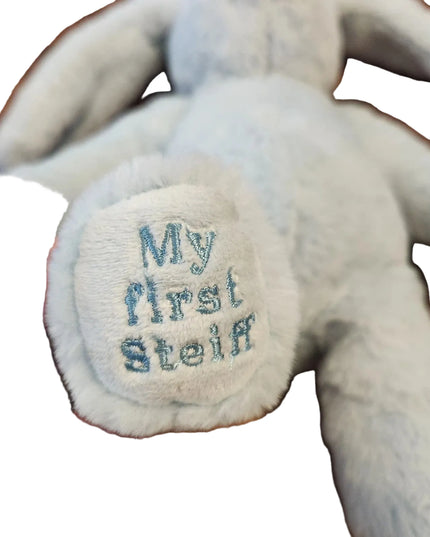 Plush toy with 'My first Steiff' embroidery on a wooden surface