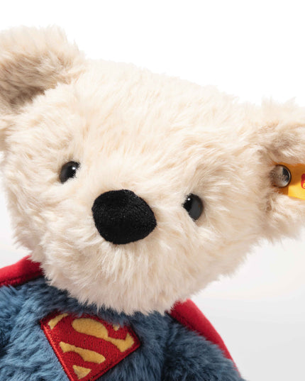 Plush bear toy with Superman cape and Steiff tag on a white background