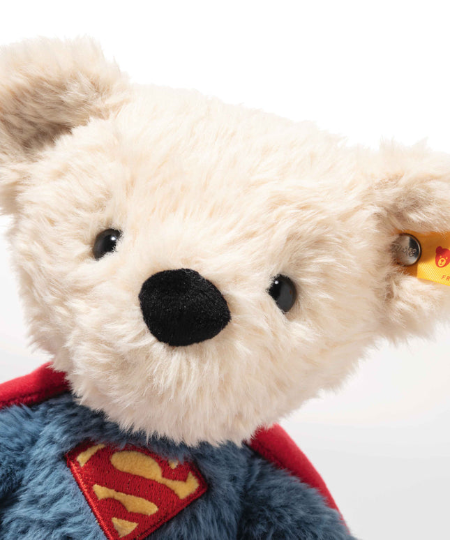 Plush bear toy with Superman cape and Steiff tag on a white background
