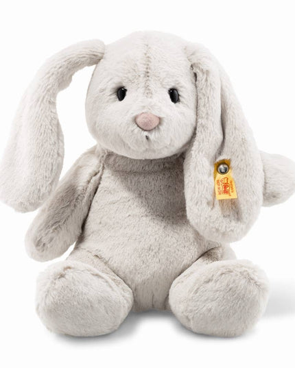 Plush rabbit toy with a visible brand tag on a white background