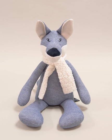 Blue stuffed animal with a white scarf on a beige background