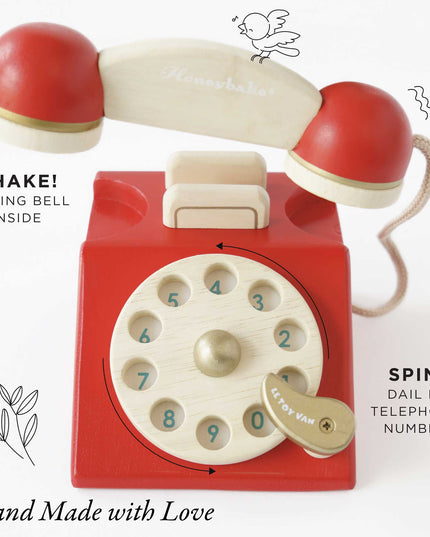Red toy telephone with a rotary dial on a white background