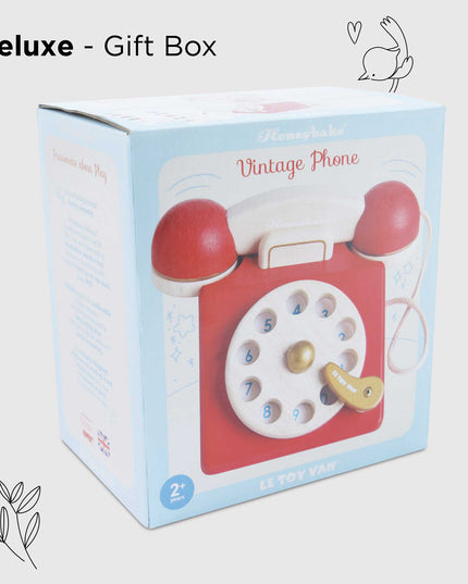 Gift box with a vintage phone toy on a light gray background