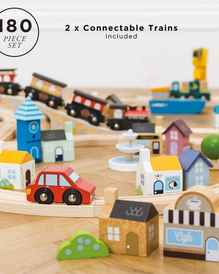 Wooden toy train set with connectable trains, houses, and a car on a wooden track.