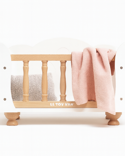 Wooden crib with pink blanket and white mattress on a white background, featuring the Le Toy Van brand.