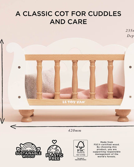 Wooden crib with dimensions and Le Toy Van branding on a light pink background