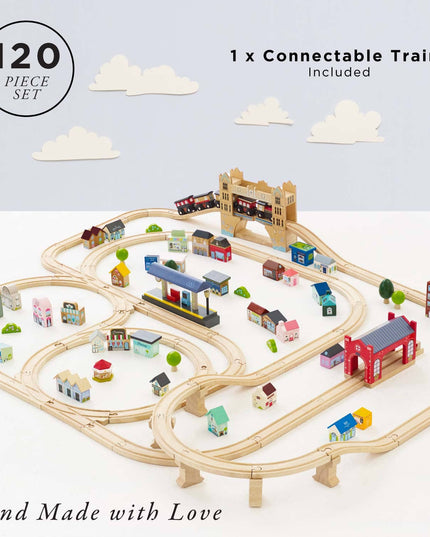 Wooden train set with tracks and small buildings on a light blue background