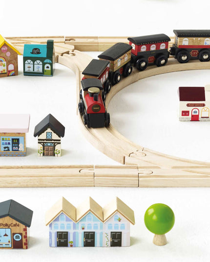 Wooden toy train set with tracks and houses on a white background