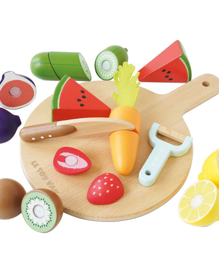 Wooden toy cutting board with colorful fruits and vegetables on a white background