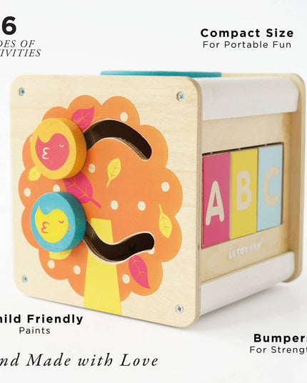 Children's wooden activity cube with colorful designs and text on a white background