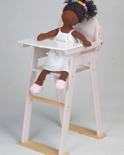 Doll sitting in a high chair with a plain background
