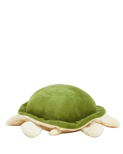 Green plush turtle toy on a light beige background