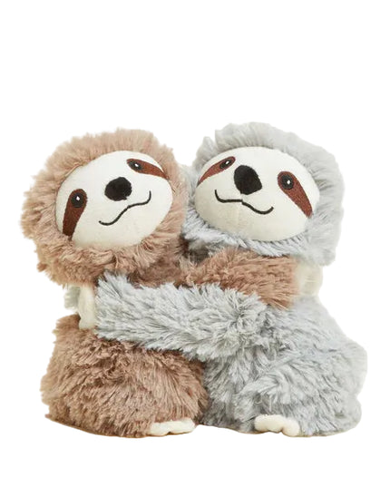 Two plush sloths hugging each other on a light beige background