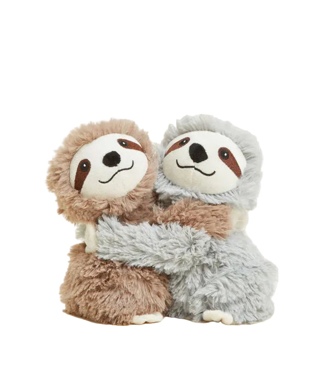 Two plush sloths hugging each other on a light beige background