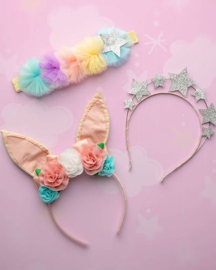 Colorful headbands with floral and star designs on a pink background